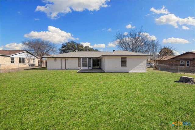 rear view of property with a patio and a lawn