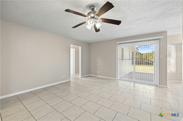 tiled spare room featuring a textured ceiling and ceiling fan