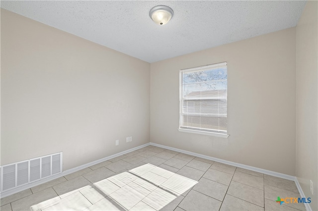 tiled spare room with a textured ceiling