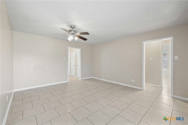 tiled empty room featuring a textured ceiling and ceiling fan