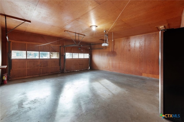 garage featuring a garage door opener and stainless steel refrigerator