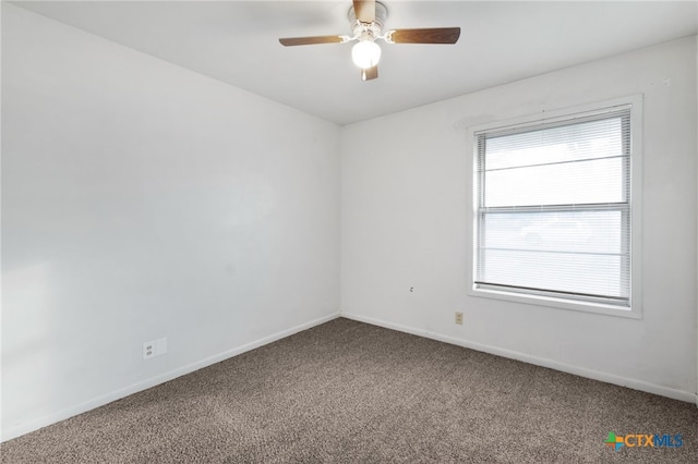 carpeted spare room featuring ceiling fan