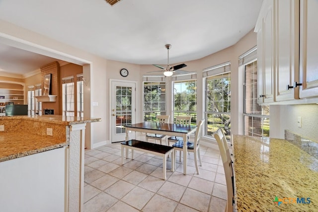 1100 Appalachian Trl, San Marcos, TX 78666 - dining area featuring baseboards, a ceiling fan, a large fireplace, and light tile patterned floors