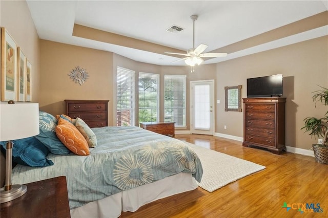 1100 Appalachian Trl, San Marcos, TX 78666 - bedroom featuring visible vents, baseboards, a ceiling fan, wood finished floors, and a raised ceiling