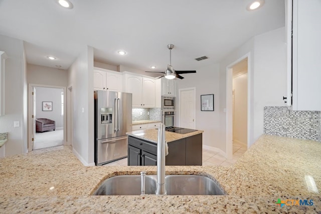 1100 Appalachian Trl, San Marcos, TX 78666 - kitchen with decorative backsplash, visible vents, appliances with stainless steel finishes, and light stone counters