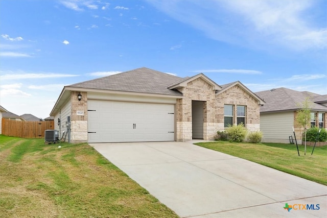 view of front of home with a front yard, cooling unit, and a garage