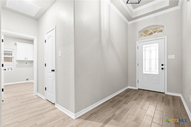 foyer with ornamental molding and light wood-type flooring