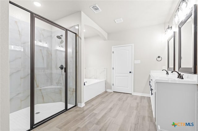 bathroom featuring vanity, shower with separate bathtub, and hardwood / wood-style floors