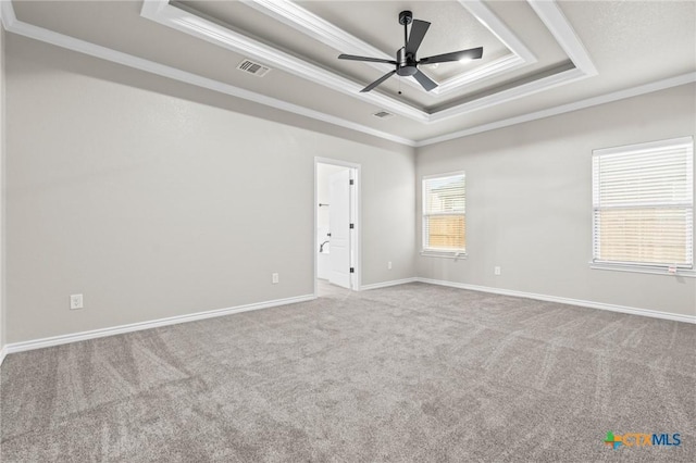 carpeted empty room featuring crown molding, ceiling fan, and a tray ceiling