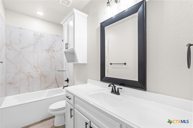 full bathroom with tiled shower / bath combo, vanity, and toilet