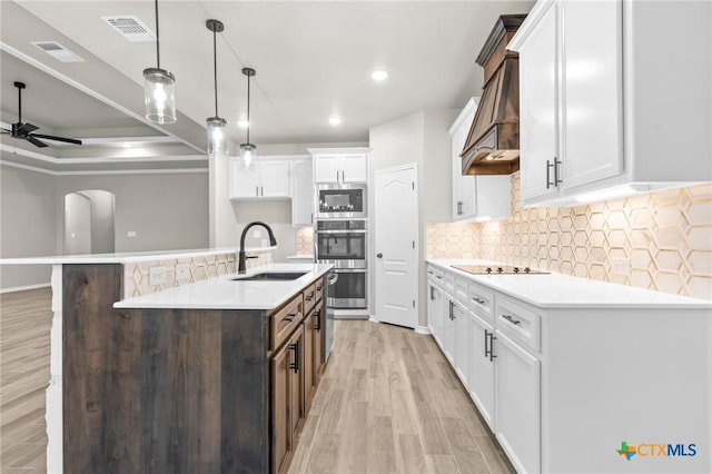 kitchen featuring white cabinetry, an island with sink, sink, dark brown cabinets, and black electric cooktop