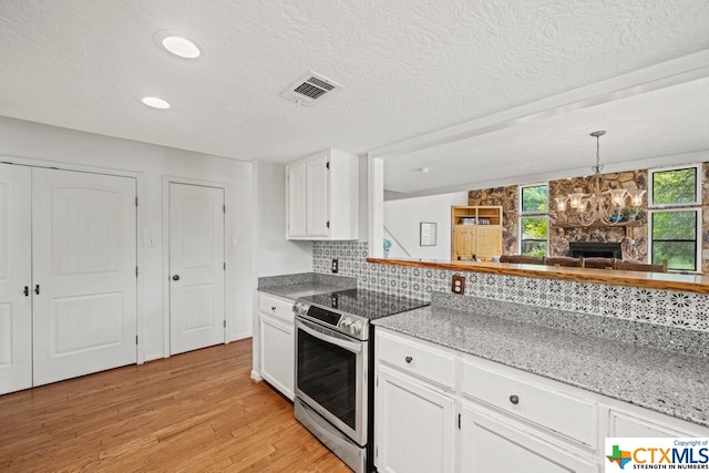 kitchen featuring white cabinets, light hardwood / wood-style floors, stainless steel electric range oven, and backsplash