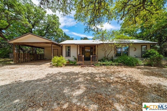 ranch-style house featuring a porch and a carport