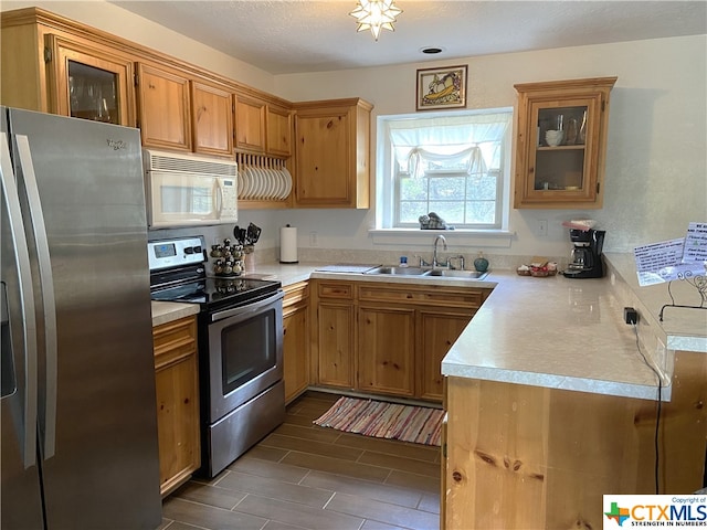 kitchen featuring appliances with stainless steel finishes, sink, and a textured ceiling