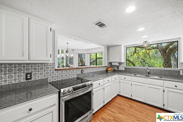 kitchen featuring sink, an inviting chandelier, stainless steel electric range, light hardwood / wood-style flooring, and white cabinets