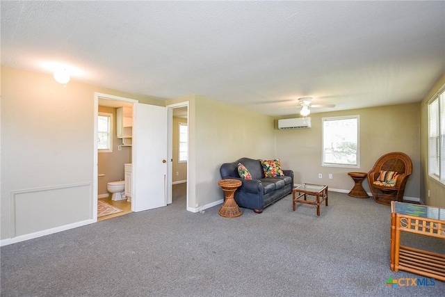 1551 Bayview Dr, Palacios, TX 77465 - living room with ceiling fan, a wall unit AC, baseboards, and carpet