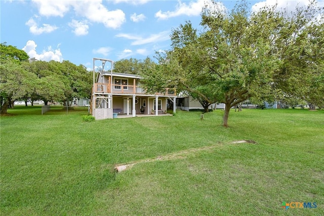 1551 Bayview Dr, Palacios, TX 77465 - rear view of property featuring a lawn, a wooden deck, stairs, and a patio area