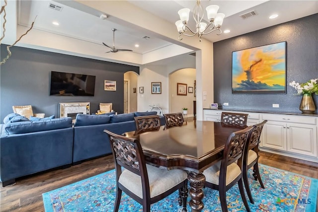 1404 Andalucia Dr, San Marcos, TX 78666 - dining area with arched walkways, dark wood finished floors, a chandelier, recessed lighting, and a tray ceiling