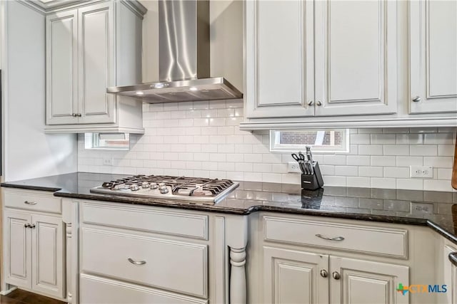 1404 Andalucia Dr, San Marcos, TX 78666 - kitchen featuring wall chimney exhaust hood, stainless steel gas cooktop, decorative backsplash, and dark stone countertops