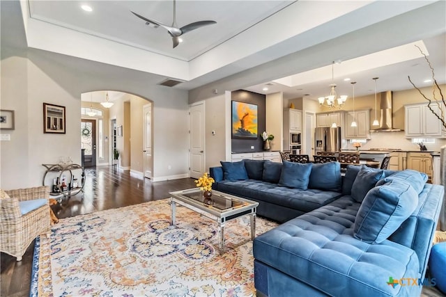 1404 Andalucia Dr, San Marcos, TX 78666 - living room featuring dark wood finished floors, arched walkways, a chandelier, ceiling fan, and baseboards