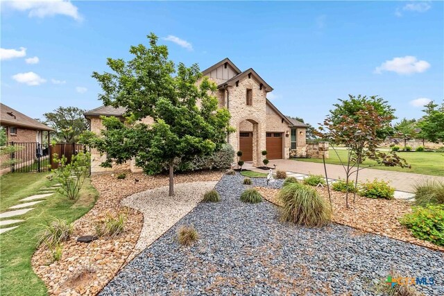 1404 Andalucia Dr, San Marcos, TX 78666 - view of front of house with fence, a garage, driveway, and stone siding