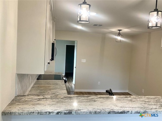 1502 Bowie Dr, Victoria, TX 77901 - kitchen featuring dark wood-type flooring, white cabinets, stainless steel microwave, electric range oven, and decorative light fixtures