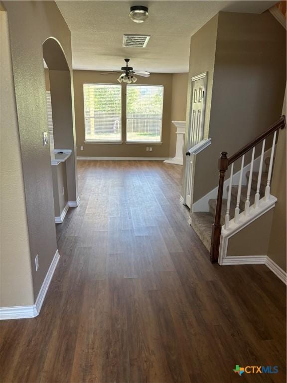 322 Lone Star Blvd, Hutto, TX 78634 - hallway with dark wood-type flooring, baseboards, arched walkways, and stairs