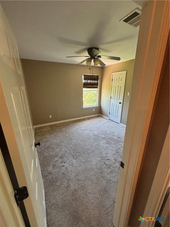322 Lone Star Blvd, Hutto, TX 78634 - unfurnished bedroom with carpet, baseboards, and ceiling fan