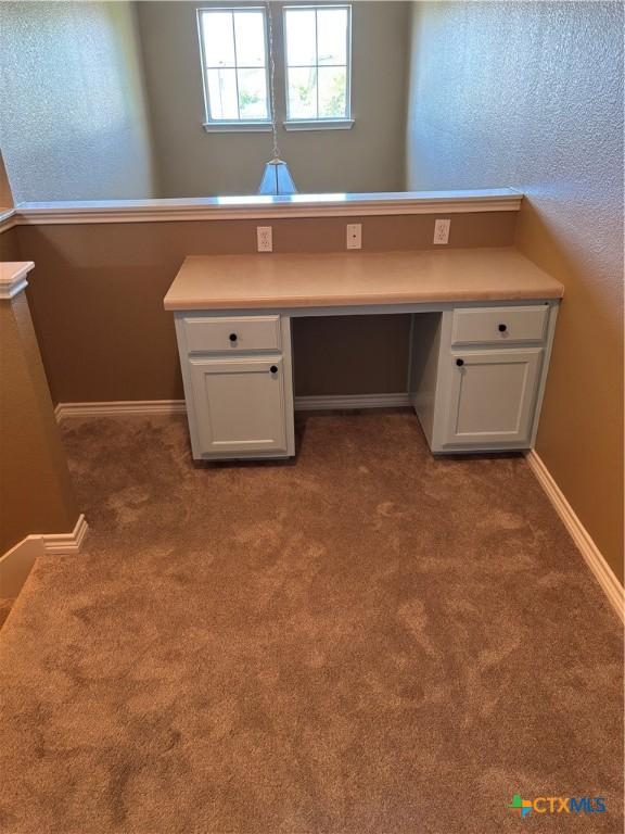322 Lone Star Blvd, Hutto, TX 78634 - unfurnished office featuring built in desk, carpet, and baseboards