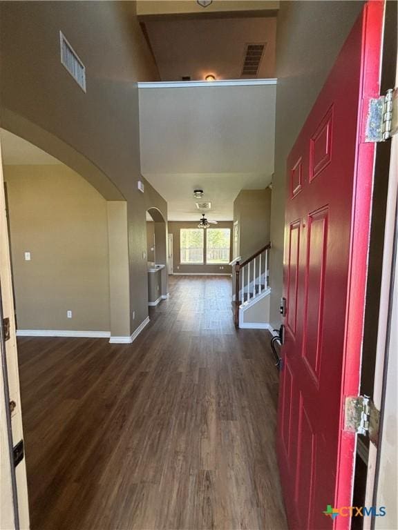 322 Lone Star Blvd, Hutto, TX 78634 - foyer with ceiling fan, arched walkways, baseboards, dark wood-type flooring, and stairs