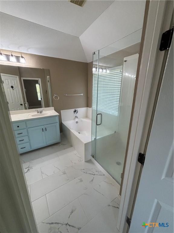 322 Lone Star Blvd, Hutto, TX 78634 - bathroom featuring marble look tile flooring, a shower stall, vanity, and a garden tub