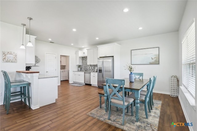 dining area with washer / dryer and dark hardwood / wood-style flooring