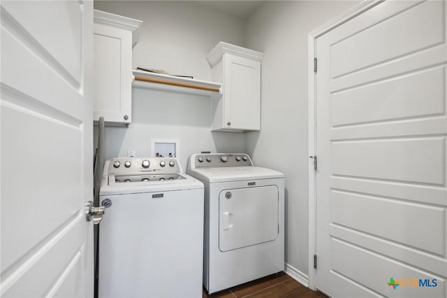 clothes washing area with cabinets and washing machine and clothes dryer