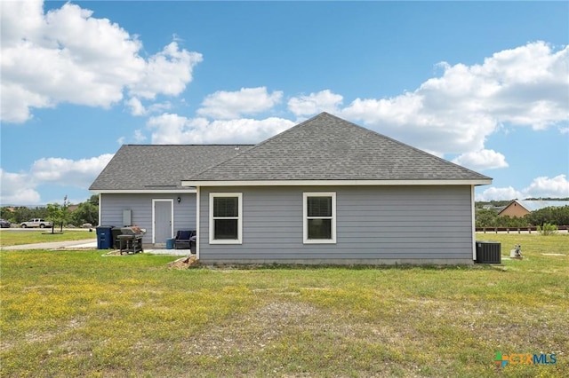 rear view of house with a yard and central AC