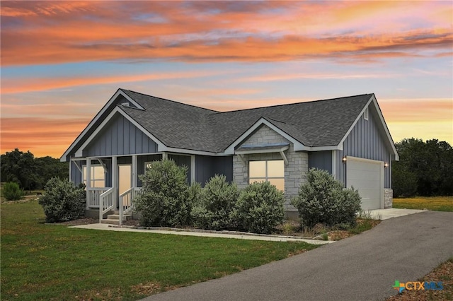 view of front of property with a garage and a lawn