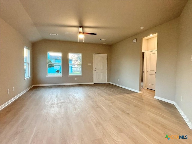 empty room with baseboards, a ceiling fan, plenty of natural light, and wood finished floors