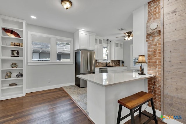 8 Herry Ct, New Braunfels, TX 78130 - kitchen featuring stainless steel appliances, a sink, white cabinets, dark wood-type flooring, and baseboards