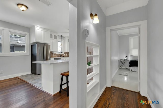 8 Herry Ct, New Braunfels, TX 78130 - kitchen with freestanding refrigerator, white cabinets, dark wood-type flooring, a breakfast bar area, and baseboards
