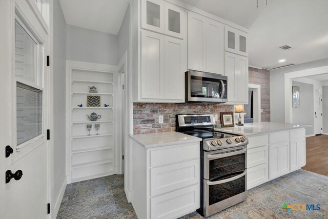 8 Herry Ct, New Braunfels, TX 78130 - kitchen featuring appliances with stainless steel finishes, light countertops, white cabinetry, glass insert cabinets, and recessed lighting