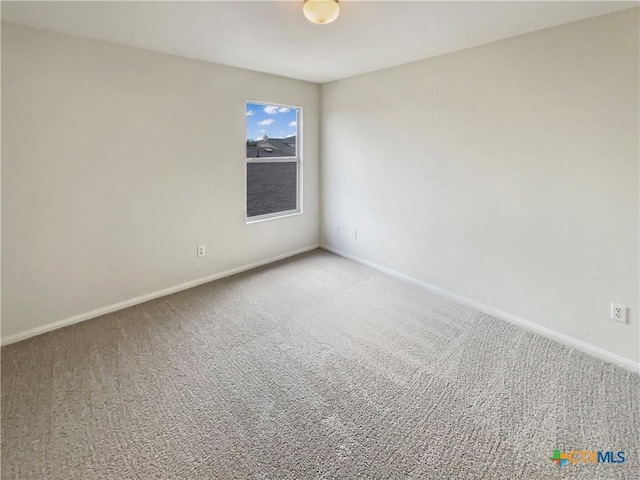 carpeted empty room with baseboards