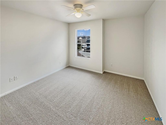 spare room with ceiling fan, baseboards, and carpet flooring