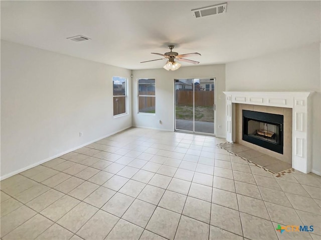 unfurnished living room with visible vents, ceiling fan, a fireplace, and light tile patterned floors