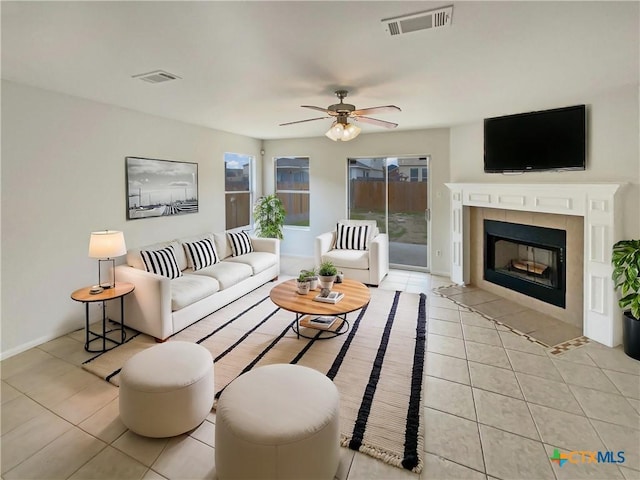 living room featuring light tile patterned flooring, a fireplace, and visible vents