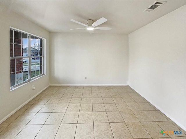 unfurnished room featuring ceiling fan, light tile patterned floors, visible vents, and baseboards