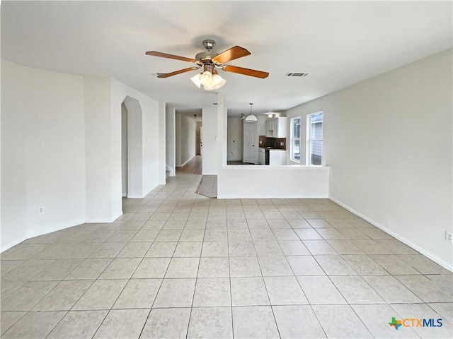 unfurnished living room featuring baseboards, visible vents, a ceiling fan, and light tile patterned flooring