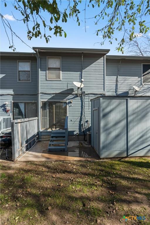 rear view of house with a patio area and a lawn