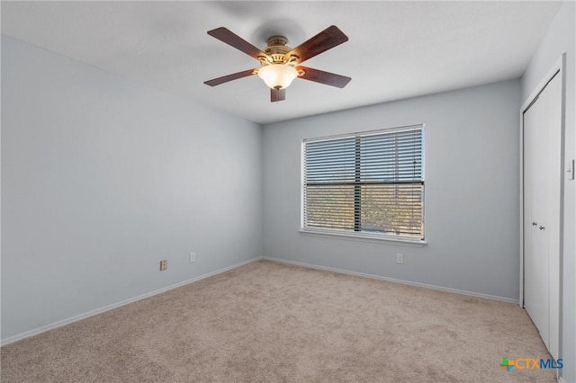 carpeted spare room with ceiling fan