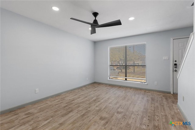 empty room with ceiling fan and light hardwood / wood-style floors