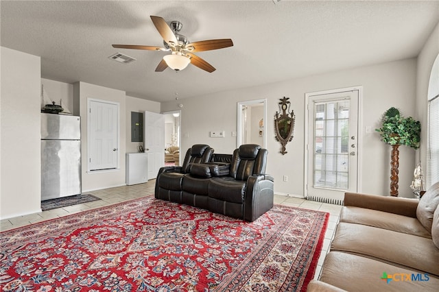 tiled living room featuring a textured ceiling and ceiling fan