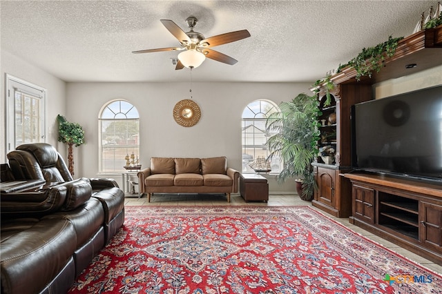 living room featuring a textured ceiling and ceiling fan